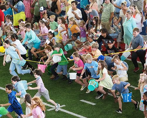 Kids running to start 校友 Easter Egg Hunt.