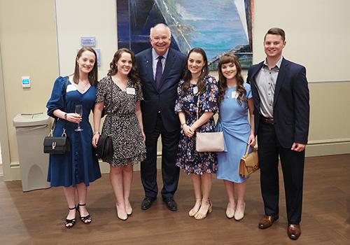 Five recent alumni standing with President Bonner.