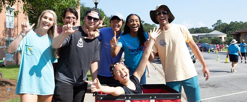 学生 at move in day holding up the J sign.